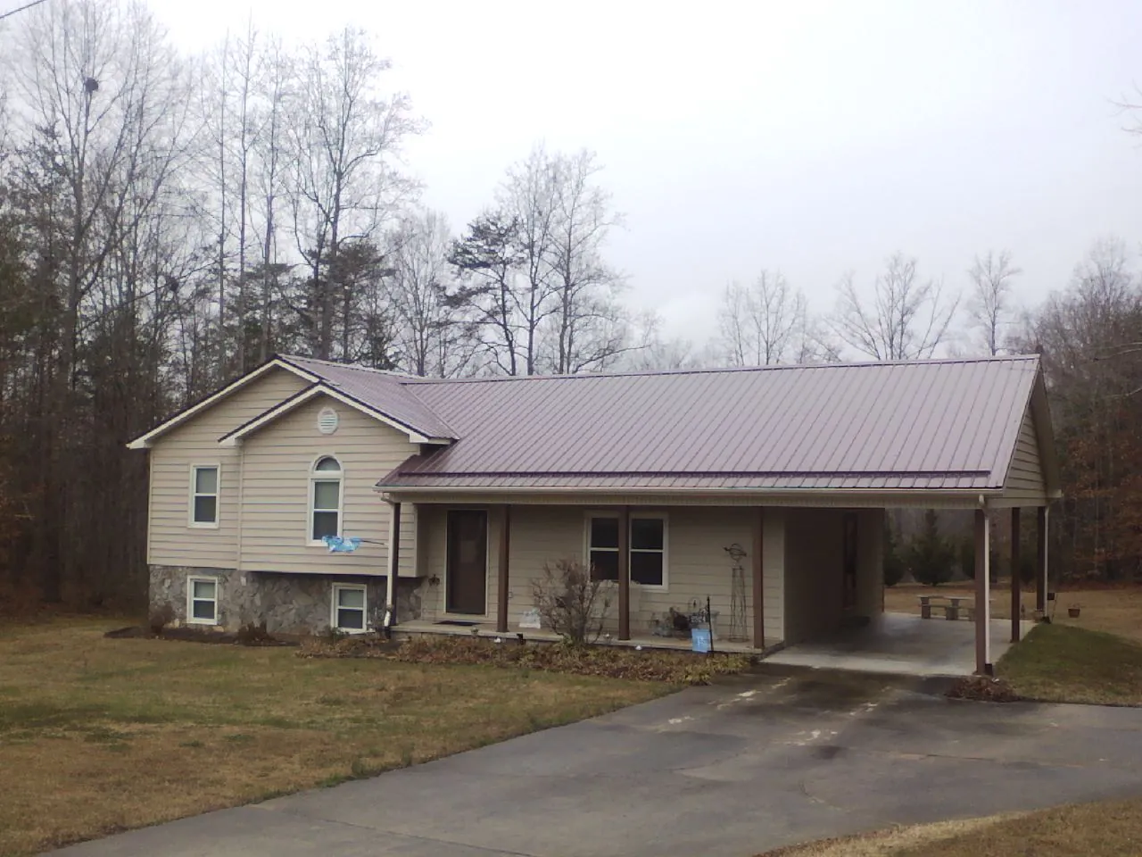Burgundy metal roof on a tan split level home with an attached carport in Clarksboro