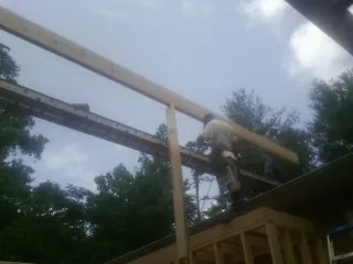 Carpenter setting a ridge beam over a new addition frame — Ice Dam Removal by Roofing Brothers in Clarksboro